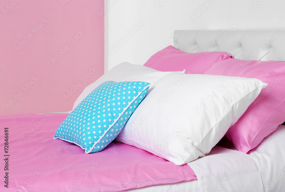 Bed in pink bed linen in room