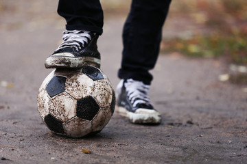 Soccer ball on ground in rainy day, outdoors