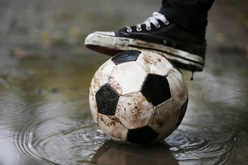 Wall Mural - Soccer ball on ground in rainy day, outdoors