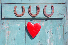 Three Old Rusty Horseshoe Luck Symbol And Red Heart On Door