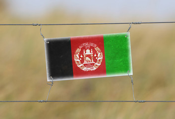 Border fence - Old plastic sign with a flag