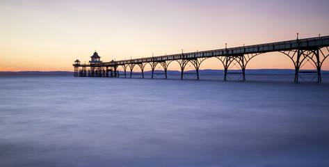 Wall Mural - Beautiful long exposure sunset over ocean with pier silhouette