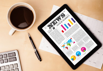 Wall Mural - tablet pc shows news on screen with a cup of coffee on a desk