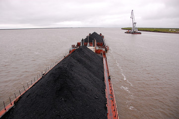 cargo ship with coal at kolyma river russia outback