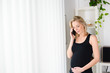 © W PRODUCTION - cheerful mature pregnant woman at home making a phone call