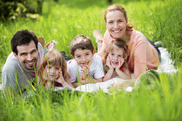 Familie mit indern macht Picknick im Grünen