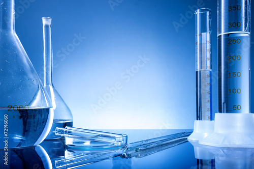 Fotografía Laboratory equipment, bottles, flasks on blue background