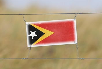 Border fence - Old plastic sign with a flag