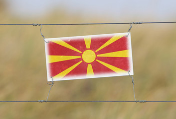 Border fence - Old plastic sign with a flag