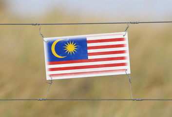 Border fence - Old plastic sign with a flag