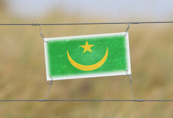 Border fence - Old plastic sign with a flag