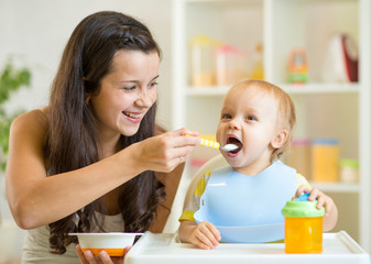 Wall Mural - Mum spoon feeding child son