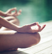 © XtravaganT - Woman Doing Outdoor Yoga at Pool Side