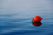 Orange Buoy On The Tranquil Blue Water
