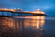 Eastbourne pier at dusk reflecting on a wet sand.