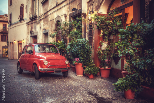 Fototapeta na wymiar Old vintage cult car parked on the street by the restaurant, in