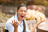 Fototapeta Kwiaty - stressed frustrated young woman screaming sitting on a bench 