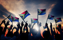 People Waving South African Flags In Back Lit