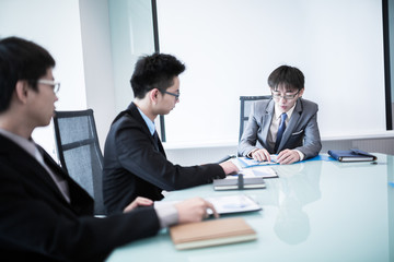 Wall Mural - Young business people sitting in board room during meeting and d