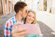© Syda Productions - smiling couple with smartphone in city