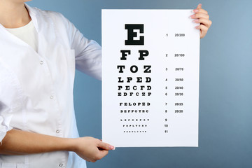 Health care, medicine and vision concept - woman with eye chart