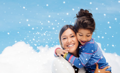 Poster - smiling little girl and mother hugging indoors