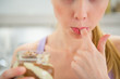 Closeup on young woman licking chocolate butter from finger