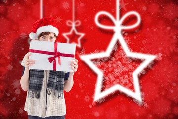 Composite image of woman holding a christmas present