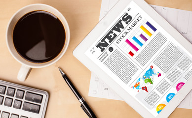 Wall Mural - tablet pc shows news on screen with a cup of coffee on a desk