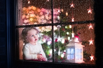 Wall Mural - Cute toddler girl during Christmas time, preparing to Xmas Eve