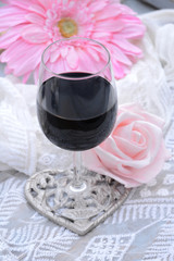 Fotomurales - glas rode wijn met roze bloemen en transparante stof
