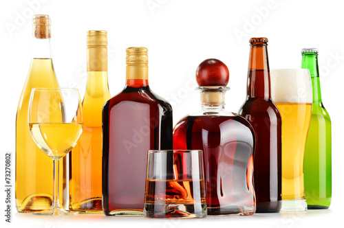 Fotografia Bottles and glasses of assorted alcoholic beverages over white