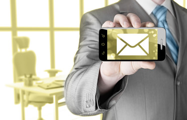 A man holding smartphone with one new message on a screen.