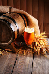 Poster - Beer barrel with beer glass on table on wooden background