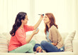 © Syda Productions - two smiling teenage girls applying make up at home