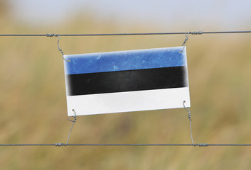 Border fence - Old plastic sign with a flag