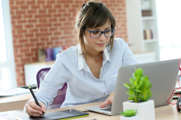 Canvas Print - Creative young woman working in office with graphic tablet