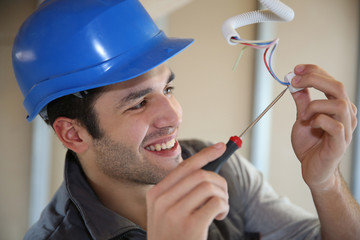 Young electrician working on building site