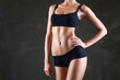 © julenochek - Slim woman's body  over dark grey background