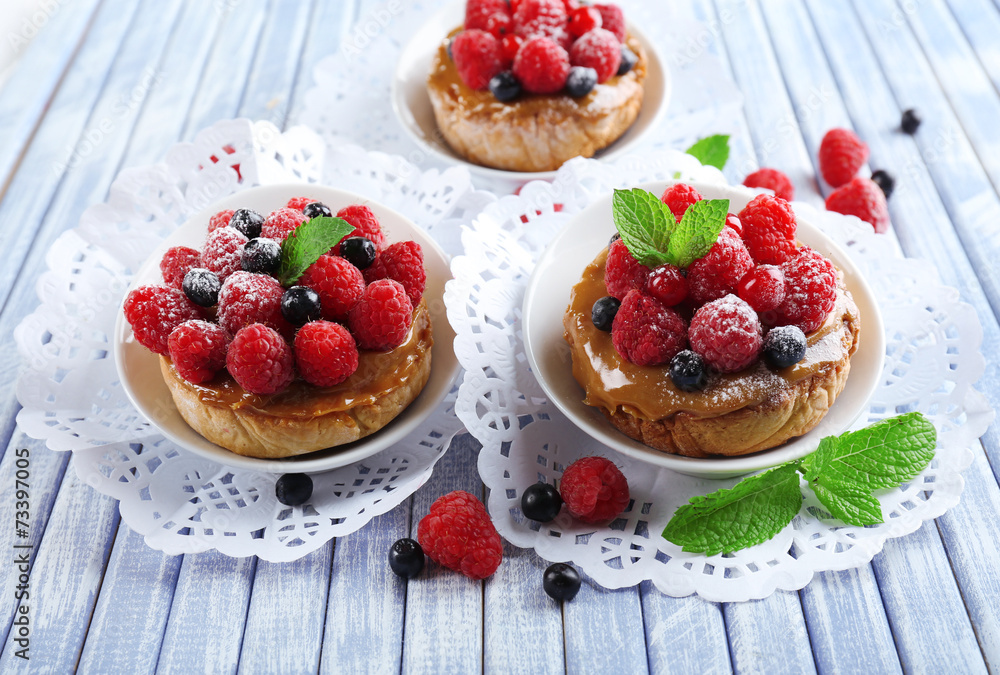 Sweet cakes with berries on table close-up