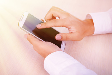 Wall Mural - Woman using smartphone on light background