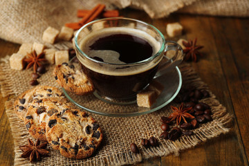 Wall Mural - Glass cup of coffee and tasty cookie on wooden background