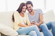 © WavebreakMediaMicro - Cute couple relaxing on couch with smartphone
