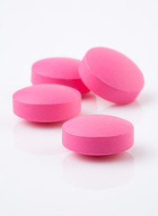 Wall Mural - Pink tablet pill on white background