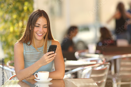Fotografia Girl texting on the phone in a restaurant