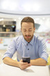 © Adam Radosavljevic - Young Businessman seating on table in restoran and use mobile de