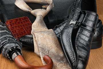 Classic mens shoes, tie, umbrella,wallet  and bag on the wooden