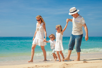 Canvas Print - Happy family walking at the beach at the day time.