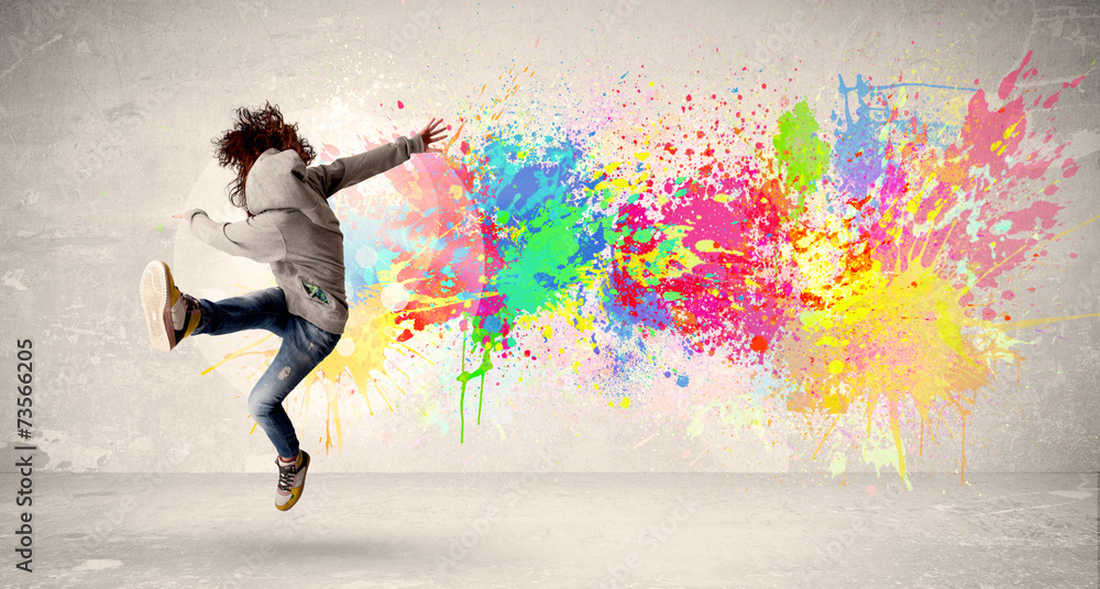Happy teenager jumping with colorful ink splatter on urban backg - obrazy, fototapety, plakaty 