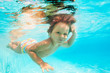 © Sergey Novikov - Cute smiling boy swimming under water of pool